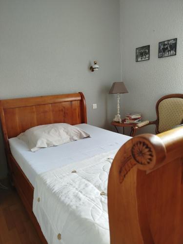 - une chambre avec un lit doté d'une tête de lit en bois et d'une table dans l'établissement La Pointe de Sel, à Salies-du-Salat