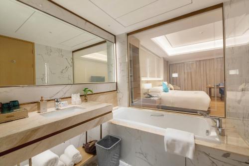黄山市Huangshan Parkview International Hotel的带浴缸和大镜子的浴室