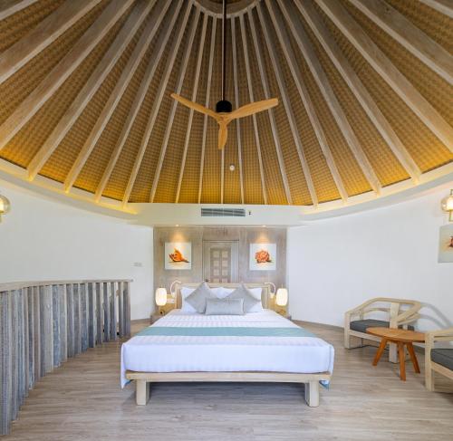 a bedroom with a bed and a ceiling at Bandos Maldives in North Male Atoll
