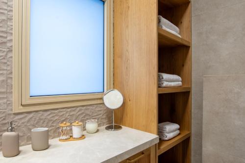 a bathroom with a vanity with a mirror and towels at סקנד פלור סוויטה מודרנית מפנקת ברמת הגולן in Qasrîne