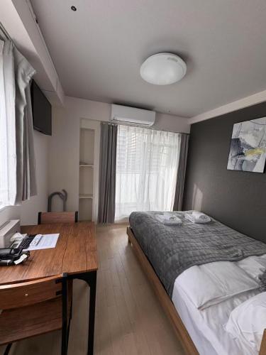 una camera da letto con un letto e una scrivania in legno di PLy ad Osaka