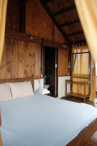 a bed in a room with wooden walls at Dreamville Beach Homestay in Phu Yen
