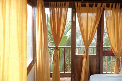 a bedroom with yellow curtains in front of a window at Dreamville Beach Homestay in Phu Yen