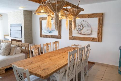 a dining room with a wooden table and chairs at Art Cabin At The Beach in Langstrand