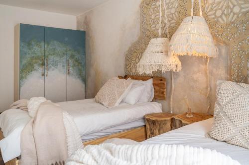 a living room with two beds and two chandeliers at Art Cabin At The Beach in Langstrand