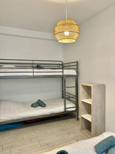 Cette chambre comprend 2 lits superposés et un lustre. dans l'établissement T3 au cœur du Touquet, Plage et commerces à 2 pas, à Le Touquet-Paris-Plage