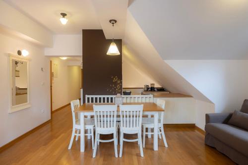 a kitchen and dining room with a table and chairs at Lakeside Apartments Bled in Bled