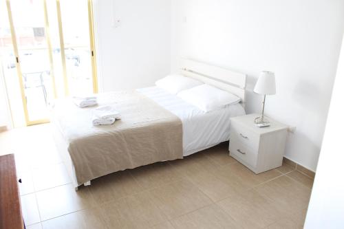 a bedroom with a bed and a lamp on a night stand at Tiffany City Apartments in Larnaka