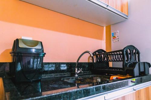 a kitchen counter with a sink and a microwave at Casa Oliveira Apart em Barra de Serinhaém-BA in Ituberá
