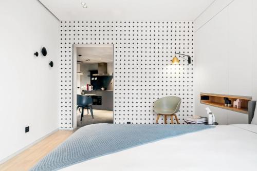 a bedroom with a bed and a table and chairs at Stey Beijing Sanlitun Boutique Hotel in Beijing