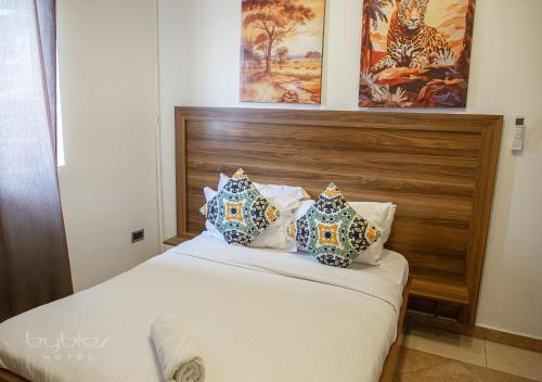 a bed with blue and white pillows on it at Byblos Hotel-Sky Osu in Accra
