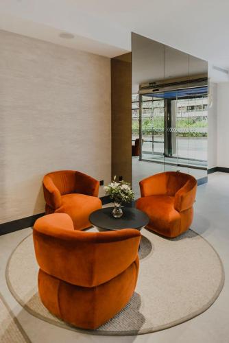 two orange chairs and a table in a room at Hotel Dimar in Valencia