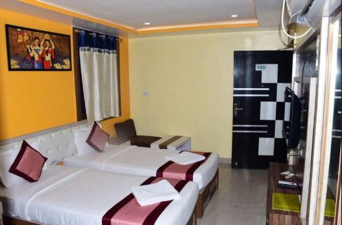 a hotel room with two beds and a table at AR Grand HOTEL in Rājgīr