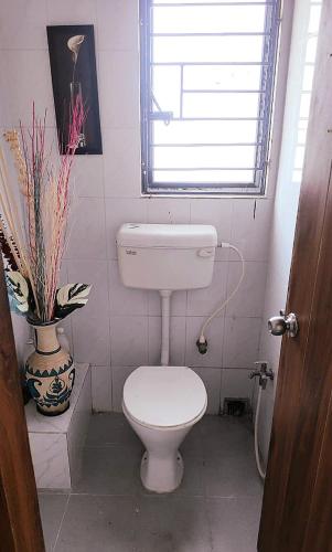 a small bathroom with a toilet and a window at Soho by the Ganges Riverside in Nangi