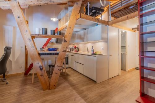 une cuisine en mezzanine avec des placards blancs et une échelle dans l'établissement Résidence Grand Roc - Ancolies 348 - Happy Rentals, à Chamonix-Mont-Blanc