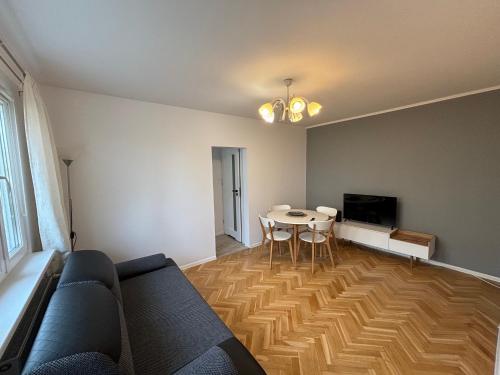 a living room with a couch and a table at Apartament Kasprzaka in Bydgoszcz