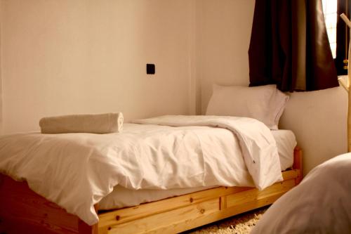 a bedroom with two beds with white sheets at Azurf - Imsouane Surf House in Imsouane