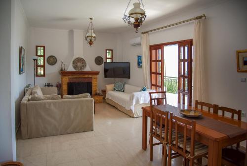 a living room with a table and a couch at Ipsipili Villa with sea views and private garden in Possidi
