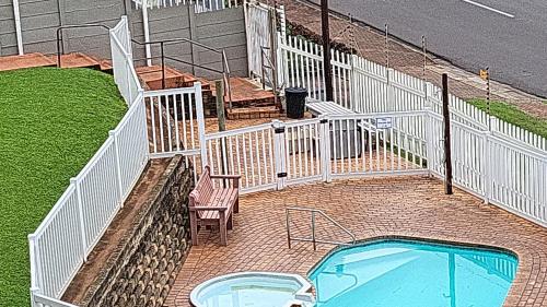 a small pool with a chair and a fence at Peacehaven Beachfront Property - Scottburgh KZN in Scottburgh