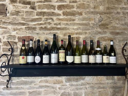 - un bouquet de bouteilles de vin assises sur une étagère dans l'établissement Le Refuge Bourguignon, à Nuits-Saint-Georges
