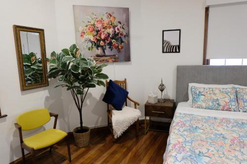 a bedroom with a bed and a chair and a plant at Secret River Cottage in Windsor