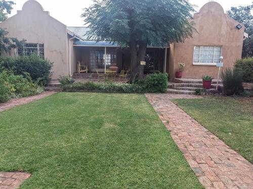 a house with a lawn in front of it at morning sun guesthouse in Hartswater