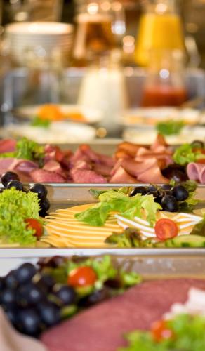 a buffet of different types of food on trays at Johanniter Gästehaus in Münster