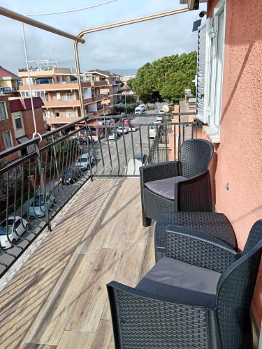 a balcony with chairs and tables on a building at Grace's Home in Ladispoli