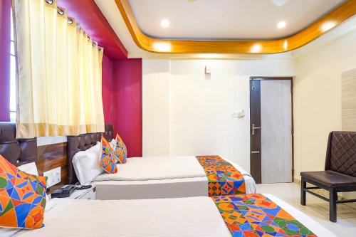 a hotel room with two beds and a chair at FabHotel I Residency - Nr St Johns Medical College in Bangalore