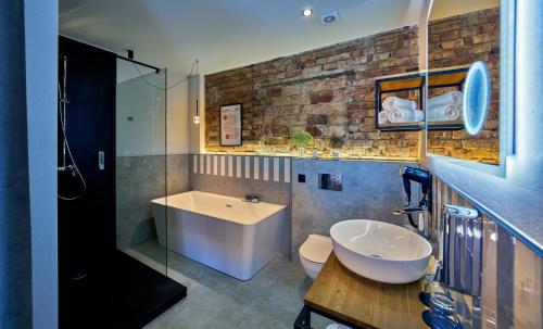 a bathroom with a sink and a tub and a toilet at apartHotel Sobieskiego 9 in Rybnik