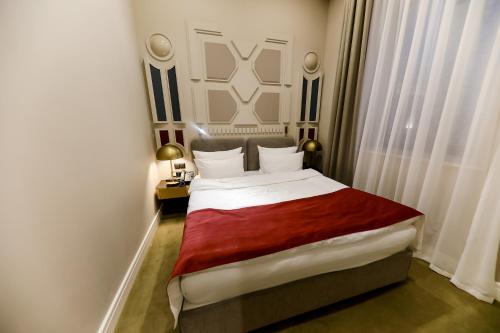 a bedroom with a large bed with a red blanket at Moselle Armenia Wellness & Medical SPA Jermuk in Jermuk