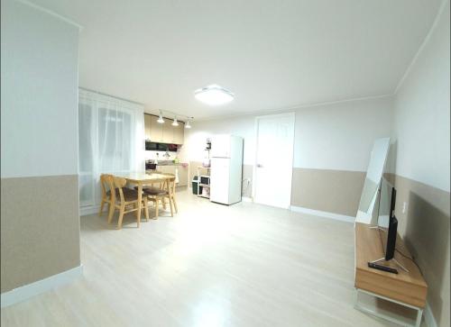a living room with a table and a kitchen at Elimhouse in Ansan