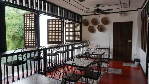 a balcony with chairs and tables and windows at Park Avenue Boutique Hotel Manila in Manila