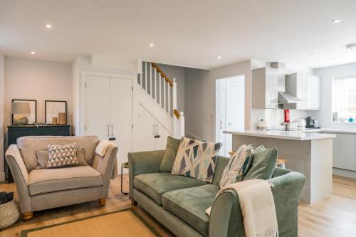 a living room with a couch and a chair at Arch Row Cottage - Stow on the Wold in Stow on the Wold