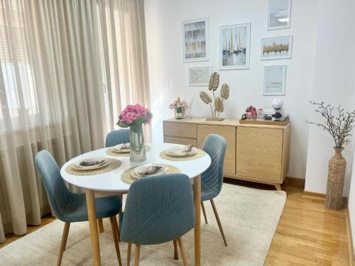 a dining room with a white table and blue chairs at BeoCity 011 in Novi Beograd