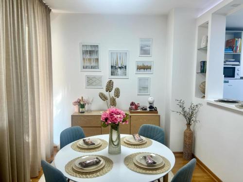 a dining room with a white table and blue chairs at BeoCity 011 in Novi Beograd