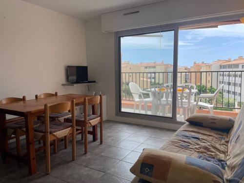 un salon avec une table à manger et un balcon dans l'établissement 057 Beverley Hills F113, au Cap d'Agde