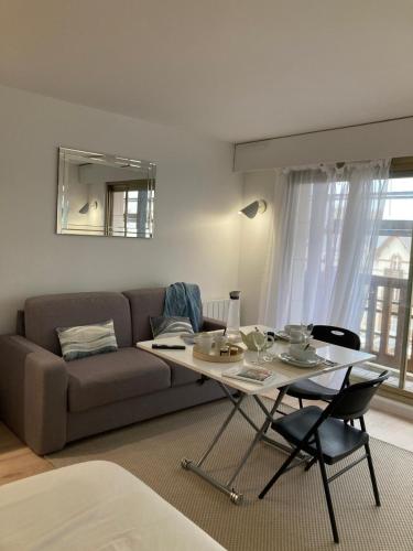 un salon avec un canapé et une table dans l'établissement Grand studio hyper centre avec balcon TOUT REFAIT MARS 2025, à Deauville