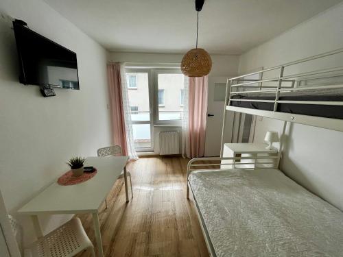 a small room with a bunk bed and a desk at Latarnik in Karwia