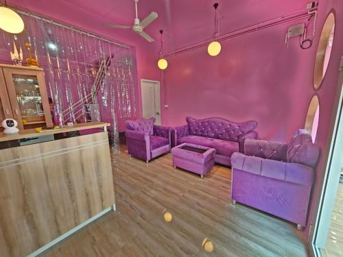 una sala de estar púrpura con sofás púrpura y un bar en Hostel In The City, en Pom Prap
