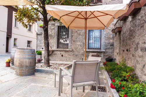 a chair and an umbrella in front of a building at Corte Giorgi in Breno