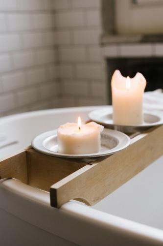 two candles sitting on plates in a bath tub at Sotto I Sassi in Guiglia