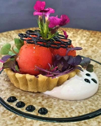 a fruit tart with flowers on top on a table at Palala Boutique Game Lodge and Spa in Tom Burke