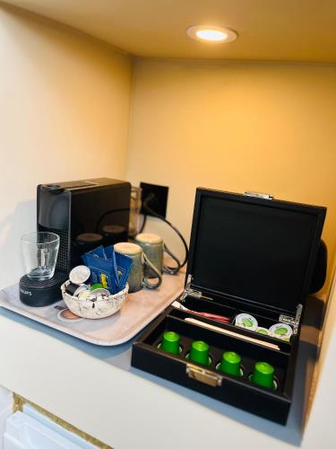 a kitchen counter with a microwave and a laptop on it at B&B Casa Blanca avec accès piscine privée sans vis à vis in Tournai
