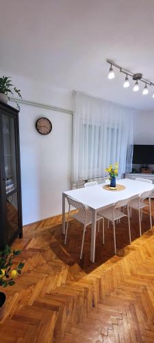 a dining room with a white table and chairs at Kuczkó Apartman in Balatonalmádi