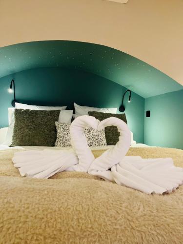 a bed with a heart made out of white sheets at B&B Casa Blanca avec accès piscine privée sans vis à vis in Tournai