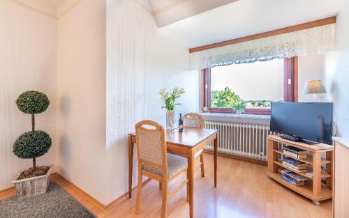 a dining room with a table and a television at Haus Schultz "Traumblick 2" in Hedehusum