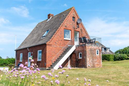 a brick house with a staircase on the side of it at Haus Schultz "Traumblick 4" in Hedehusum