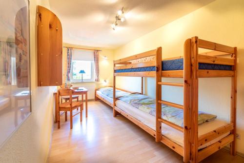 a room with two bunk beds and a table at Ferienhof Bruhn "Nr 1" in Midlum
