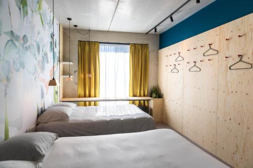 a bedroom with two beds and a window at Moloko, modern designed sleep & shower hotel in city center, Digital key by SMS in Enschede